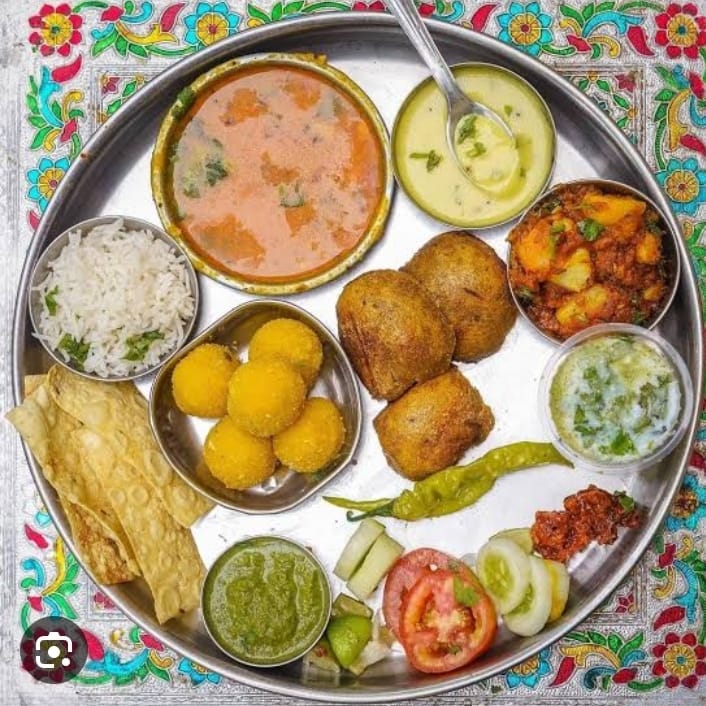 Dal Bati Thali (Dal-Bati, Papad Katran, Green Salad, Jeera Aloo, Kadi, Laddu)